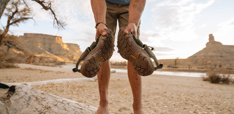 a man holding his dirty sandals