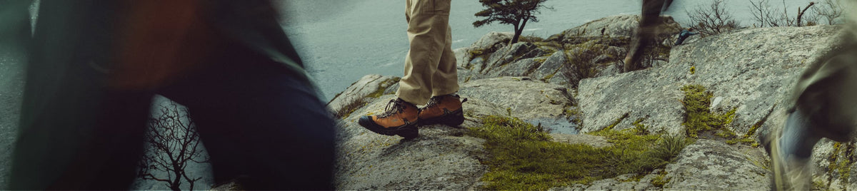 Wanderer in KEEN Trekkingschuhen auf Felsklippe mit Blick aufs Meer - wasserfeste Hiking-Boots für Küstenwanderungen