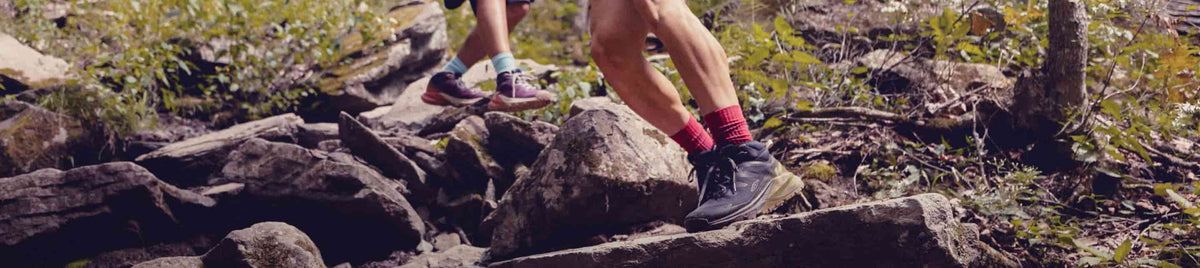 Person pausiert auf Felsen bei Dämmerung und trägt wasserdichte KEEN Targhee Apex Mid Wanderschuhe.