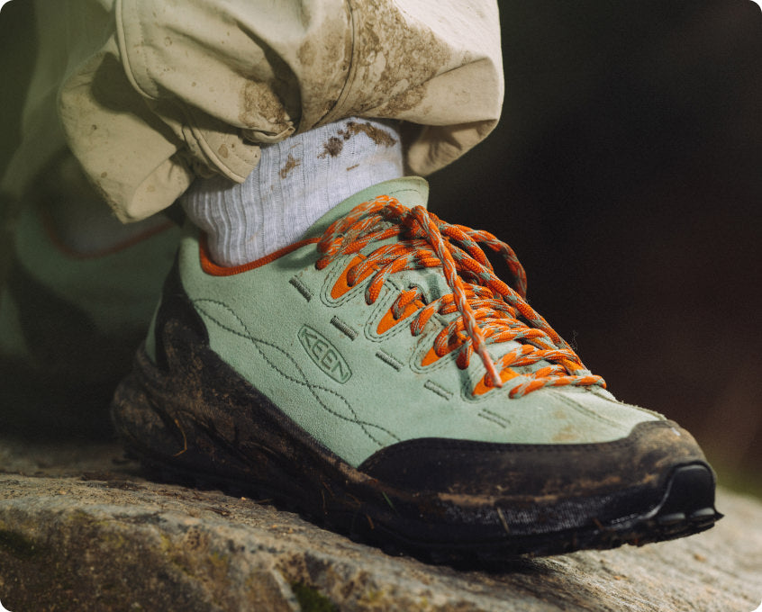 KEEN Jasper Zionic Sneaker mint-grün mit orangenen Schnürsenkeln auf Felsen