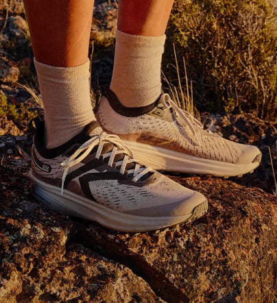 Helle KEEN Trailrunning-Schuhe auf Felsen im warmen Abendlicht.