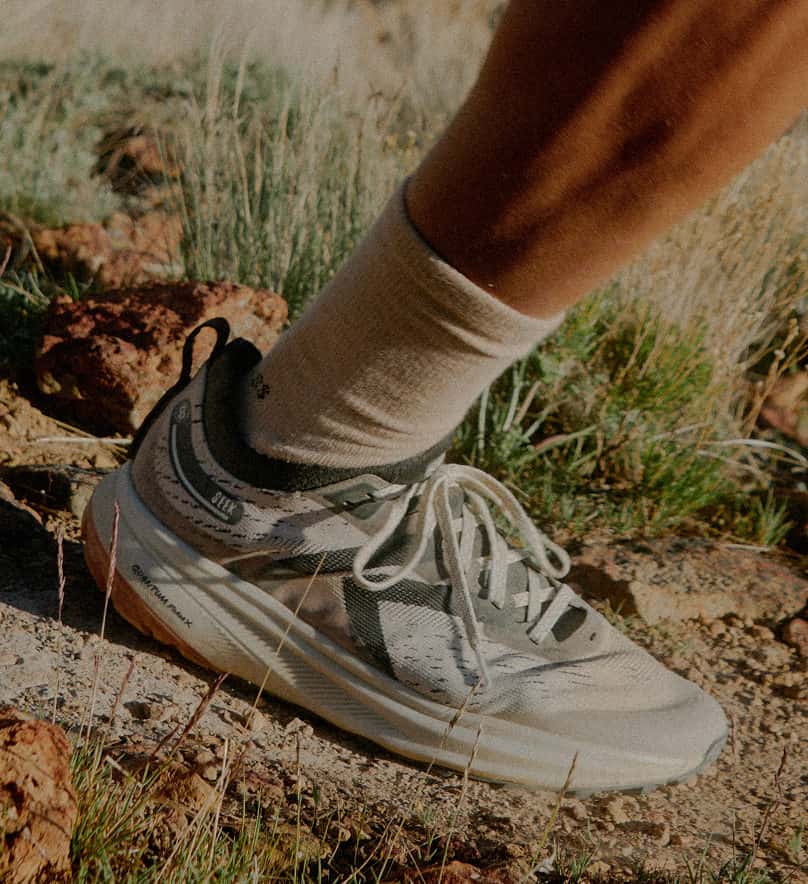 KEEN Seek Trailrunning Schuhe für Herren zwischen Gräsern und Steinen