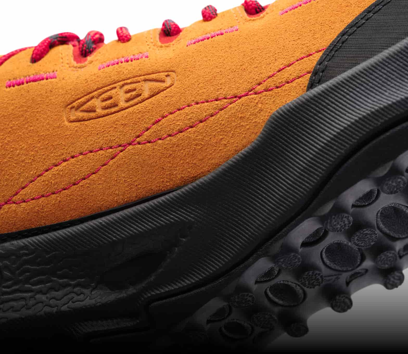 Nachansicht der Außenseite eines orangen Veloursledersneakers mit KEEN Logo, roten Schnürsenkeln, roten Nähten und schwarzer Außensohle.